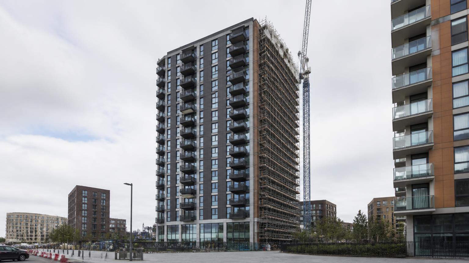 Modern residential tower of the type assessed at Pinnacle Tower in Wembley, clad in dark glazing with scaffolding to one elevation