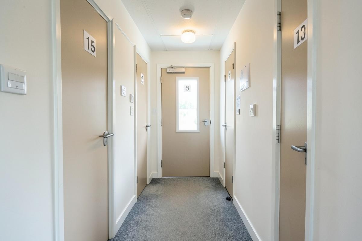 Shared house hallway with fire door, closer and interlinked smoke detector